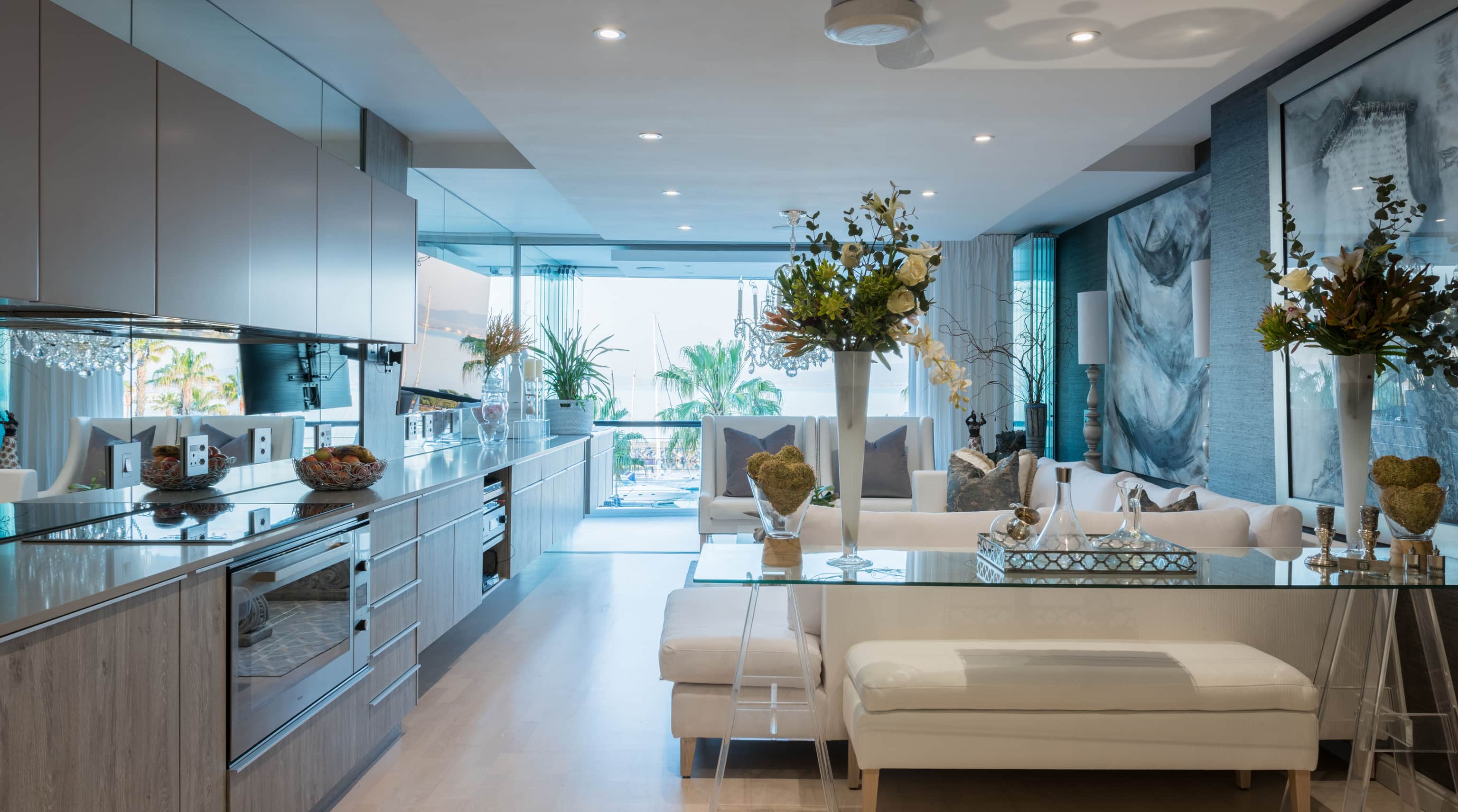 Open-plan kitchen with washed oak cabinetry running toward the lounge and balcony